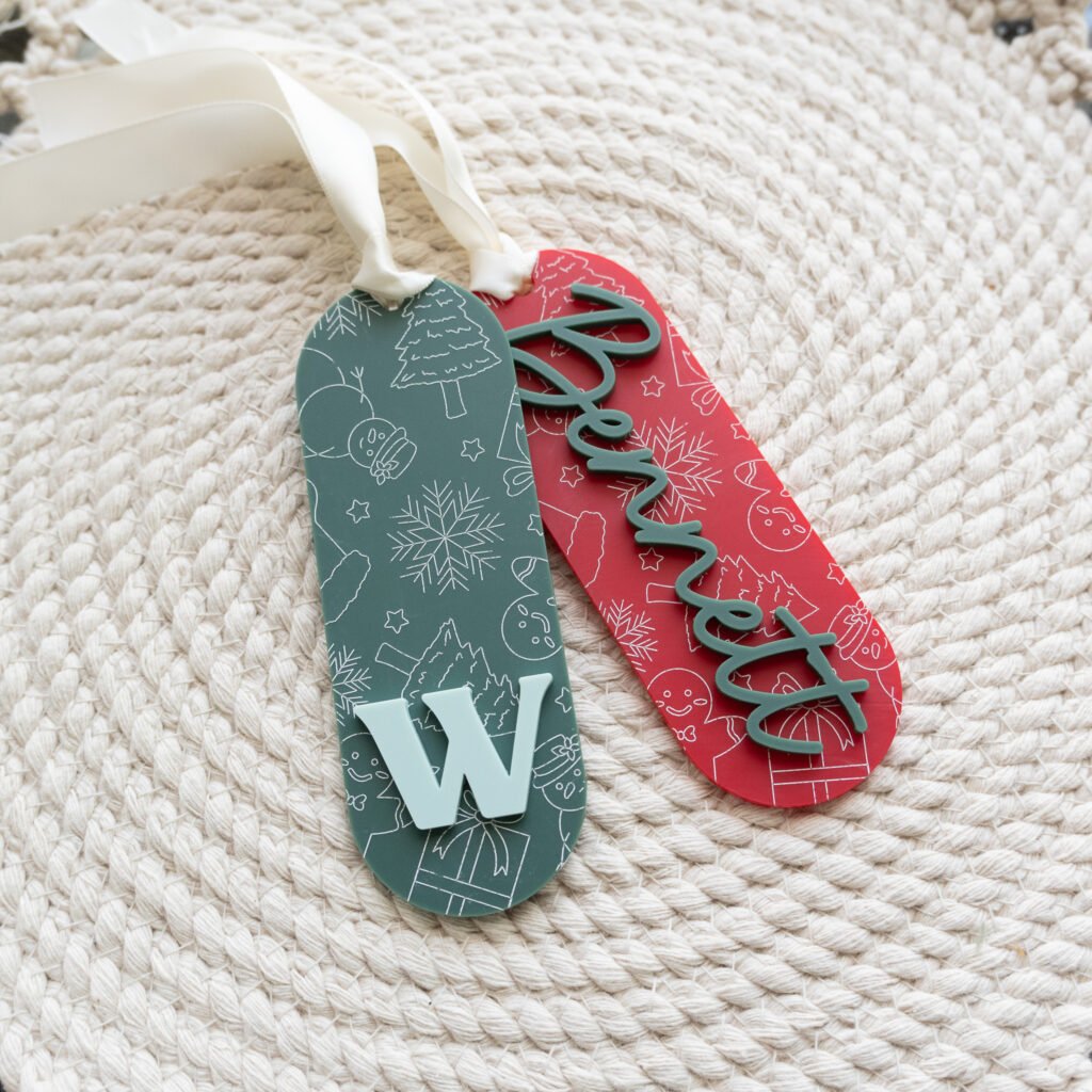 Personalized red and green Christmas stocking tags with layered acrylic names and initial