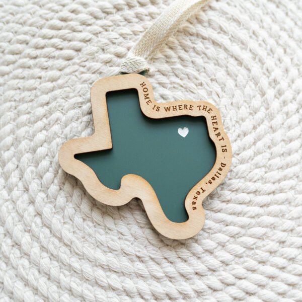 green acrylic state ornament with layered wood, shown in the shape of Texas with the words "home is where the heart is - Dallas, Texas" engraved and a heart over the dallas area