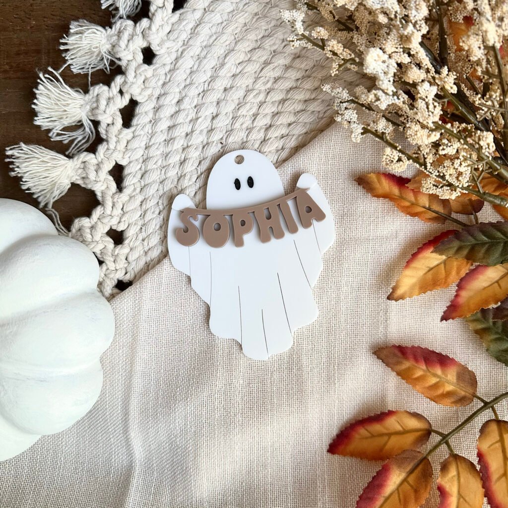 An acrylic keychain o f a ghost holding a banner of the name Sophia