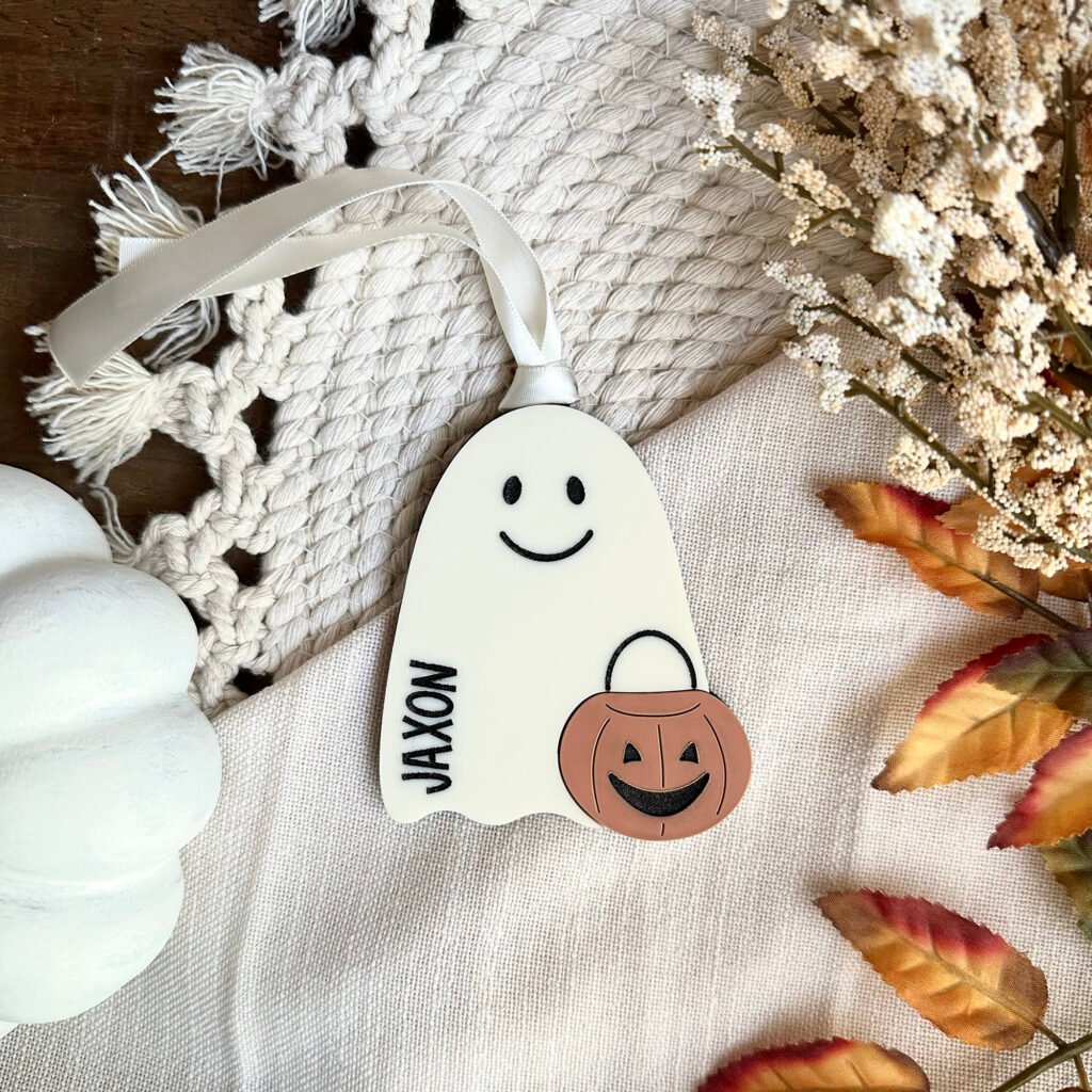 An acrylic keychain with a Ghost and pumpkin with the name Jaxon engraved