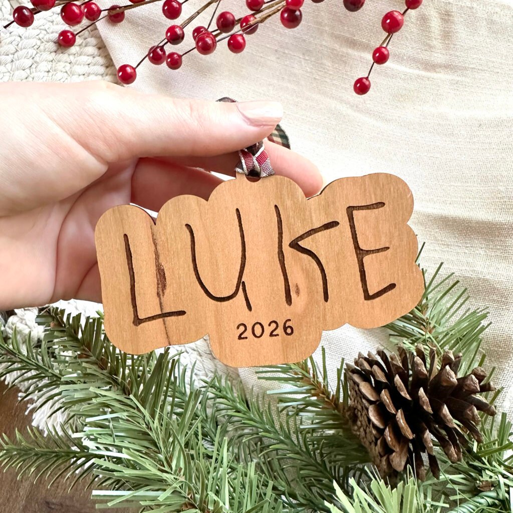 A wooden ornament with the name Luke engraved in child's handwriting