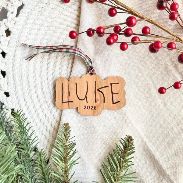 A wooden ornament with the name Luke engraved in child's handwriting