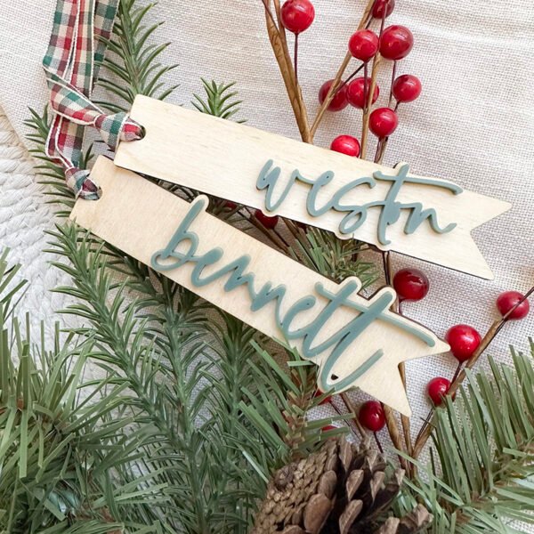 Two wood and green acrylic stocking tags with the names Weston and Bennett in a modern script font